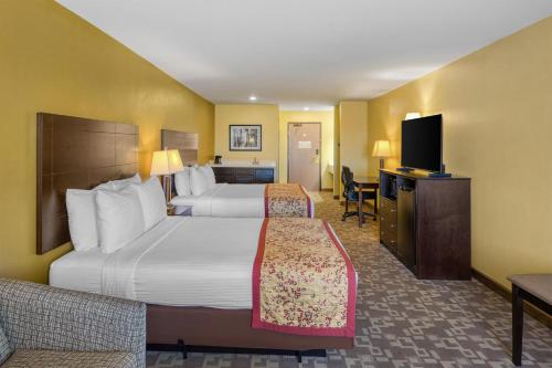 a hotel room with two beds and a flat screen tv at Best Western Blackfoot Inn in Blackfoot