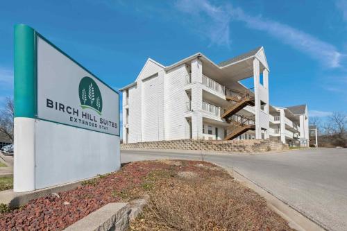 a building with a sign in front of it at Birch Hill Suites Kansas City - Independence in Independence
