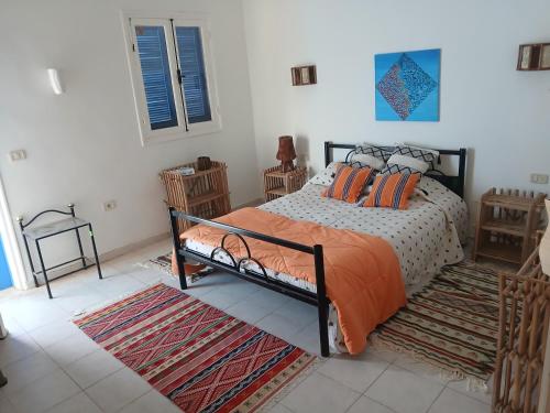 a bedroom with a bed with orange pillows on it at Dar Cally Maison d Artiste in Midoun