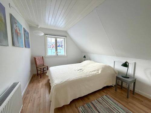 a bedroom with a bed and a table and a window at Beachhouse Humlebæk in Humlebæk