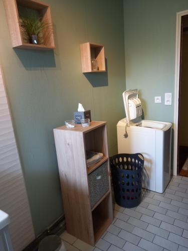 a room with a small shelf next to a refrigerator at Gîte de la belle attente in Marques