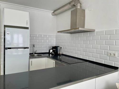 a kitchen with white walls and a black counter top at Estudio Vista Mar & Piscina - 200 m de la playa in Aguadulce