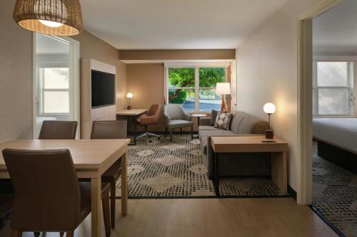 a hotel room with a bed and a living room at Residence Inn Phoenix Mesa in Mesa