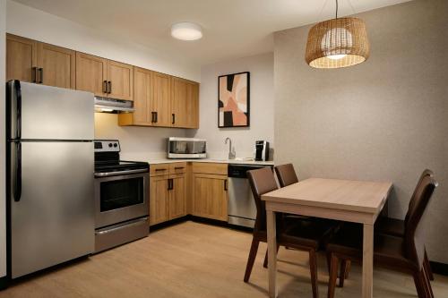 a kitchen with a table and a stainless steel refrigerator at Residence Inn Phoenix Mesa in Mesa