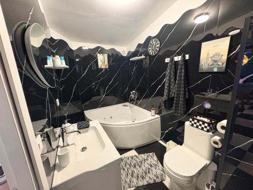 une salle de bain en noir et blanc avec une baignoire et des toilettes dans l'établissement La suite rétro, 