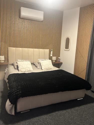 une chambre avec un grand lit aux draps et oreillers noirs dans l'établissement La suite rétro, 