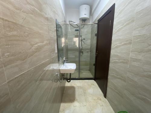 a bathroom with a sink and a glass shower at Tainaliel Homes and Properties in Mama