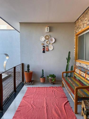 a room with plates on the wall and a red rug at Pousada e Edícula in Jabuticabal