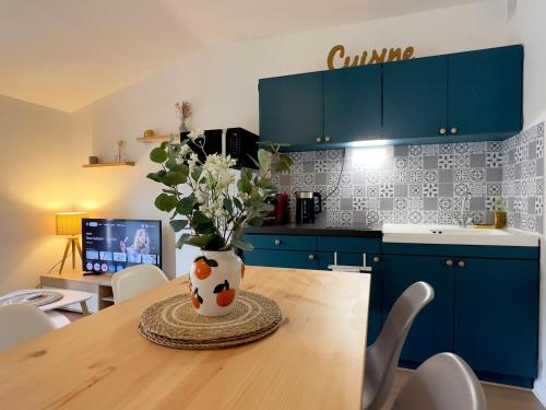 a kitchen with a table with a vase with flowers at Cocon de douceur en centre ville in Le Puy-en-Velay