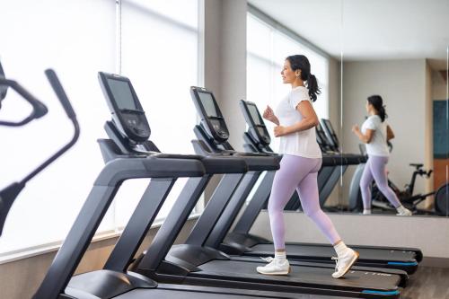 a woman running on a treadmill in a gym at Hyatt Place Piedras Negras in Piedras Negras