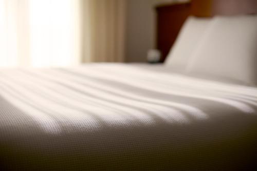 a close up of a white bed in a room at Hyatt Place Piedras Negras in Piedras Negras