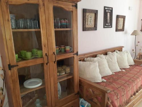a wooden cabinet with white pillows in a bedroom at MyM in Costa Azul