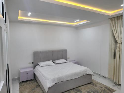a white bedroom with a bed and a ceiling at Ethiopian dream in Addis Ababa
