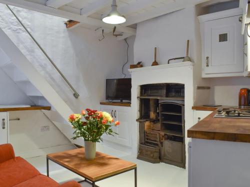 a kitchen with a table with a vase of flowers at Hogwood Cottage in Knaresborough