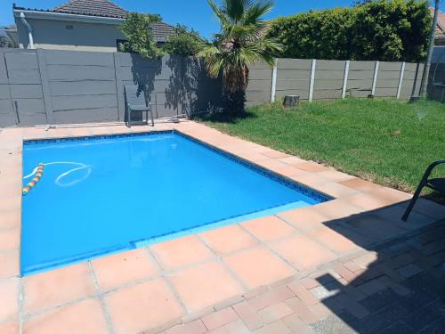 a swimming pool in a yard next to a fence at The Berna in Cape Town