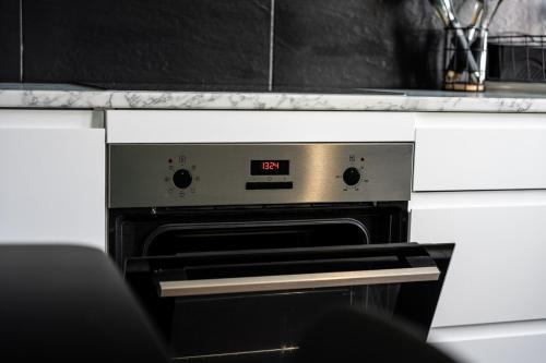 an oven with a clock on it in a kitchen at Spacious 4-Bed Apartment · Sleeps 6 · City Centre in Nottingham