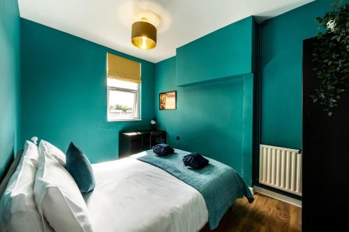 a bedroom with green walls and a white bed at Spacious 4-Bed Apartment · Sleeps 6 · City Centre in Nottingham