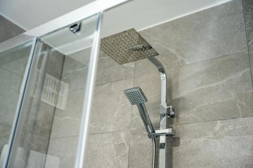 a shower with a shower head in a bathroom at Spacious 4-Bed Apartment · Sleeps 6 · City Centre in Nottingham