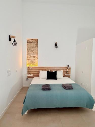 a bedroom with a large bed with a blue blanket at Dama Apartamentos Turísticos Toledo in Toledo
