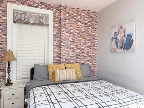 a bedroom with a bed and a brick wall at Suite One King Bed 2TVs Free Parking & museums in Richmond
