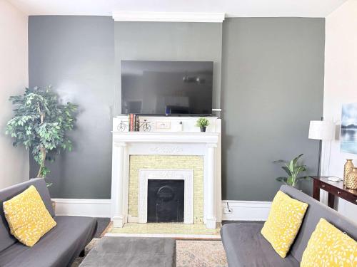 a living room with two couches and a fireplace at Suite One King Bed 2TVs Free Parking & museums in Richmond
