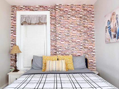 a bedroom with a brick wall and a bed at Suite One King Bed 2TVs Free Parking & museums in Richmond