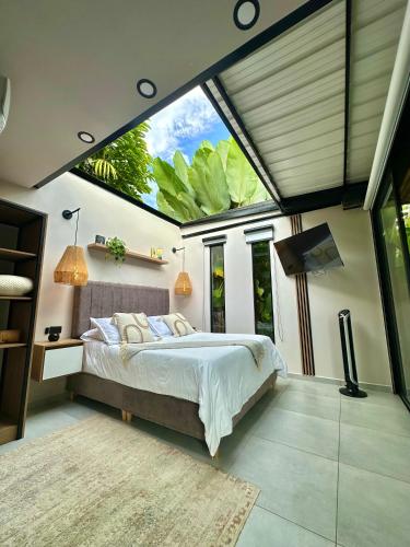a bedroom with a bed and a large window at Cielo Abierto Cabaña Glamping in Quimbaya