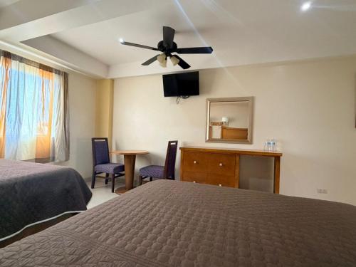 a bedroom with a bed and a ceiling fan at Hotel Posada de Santiago in Tijuana