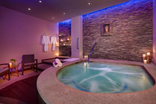 a hot tub in a room with a brick wall at GR Solaris Lighthouse - All Inclusive in San José del Cabo