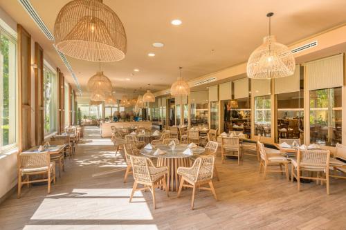 a restaurant with tables and chairs and chandeliers at GR Solaris Lighthouse - All Inclusive in San José del Cabo
