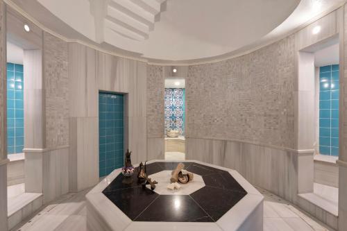 a bathroom with a tub with two statues in it at Limak Arcadia Sport Resort Belek in Belek