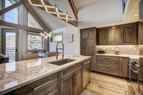 a kitchen with wooden cabinets and a sink at The Pines Lodge, a RockResort, by Vail Resorts in Beaver Creek