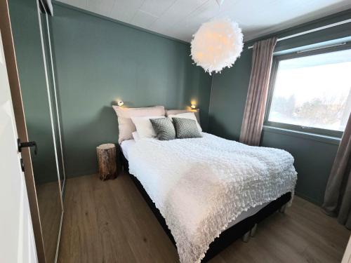 a bedroom with a bed and a chandelier at Fygle living in Vestvågøya