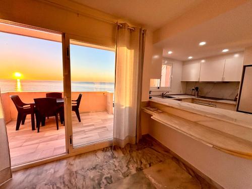 a kitchen with a view of the ocean from the balcony at Diletta Beach Estepona in Estepona