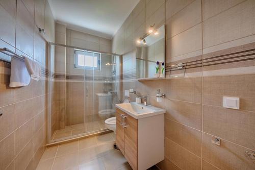 a bathroom with a toilet and a sink and a shower at Mir i More in Dobra Voda