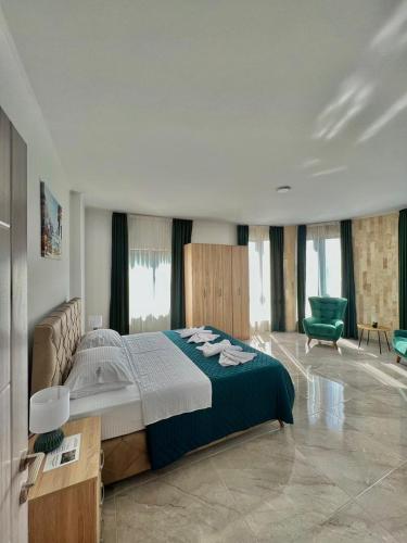 a bedroom with a large bed and a green chair at Mir i More in Dobra Voda