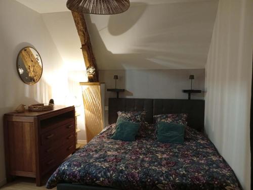 a bedroom with a bed and a dresser and a clock at L'harmonie des Oiseaux in Meyronne