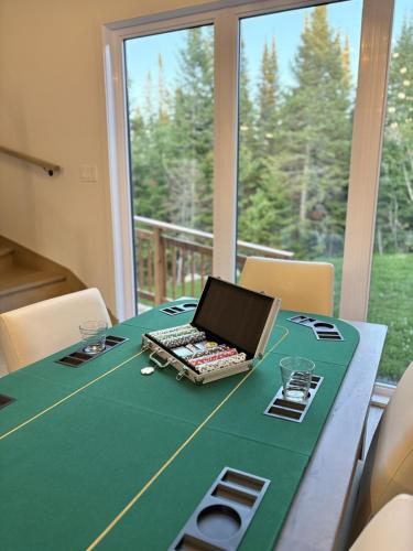 a table with a laptop computer on top of it at Le Kouzy - Spa, Foosball, Pool table, Game Room in Sainte-Lucie-de-Doncaster
