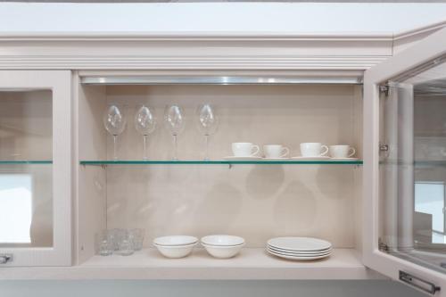 a shelf with bowls and cups and plates on it at HomeRent Bucuresti Studio in Chişinău
