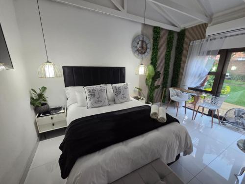 a bedroom with a large bed and a table and chairs at Indulge Deluxe Accommodation in Middelburg