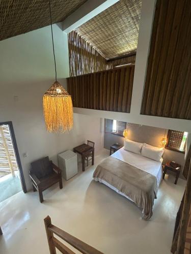 a bedroom with a bed and a chandelier at Pousada Villa Gûyrá in Trancoso