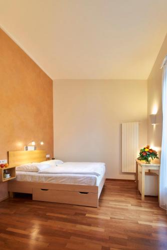 a bedroom with a large white bed and wooden floors at Town Hotel Wiesbaden - kleines Privathotel in Bestlage in Wiesbaden