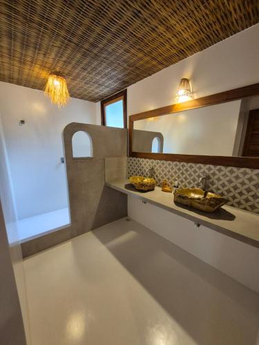 a bathroom with a sink and a mirror at Pousada Villa Gûyrá in Trancoso