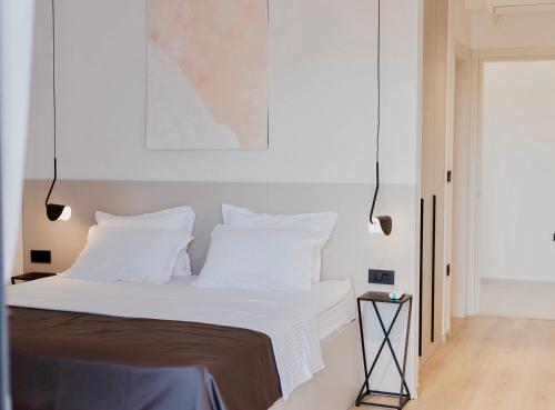 a bedroom with a bed with white sheets and pillows at White Villa, Brac in Splitska