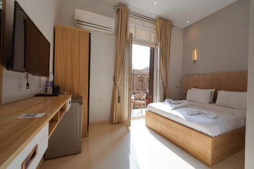 castello hotel في القاهرة: غرفة نوم بها سرير وتلفزيون ونافذة