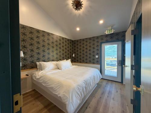 a bedroom with a large white bed and a window at The Breeze Beachfront Resort in Surfside Beach