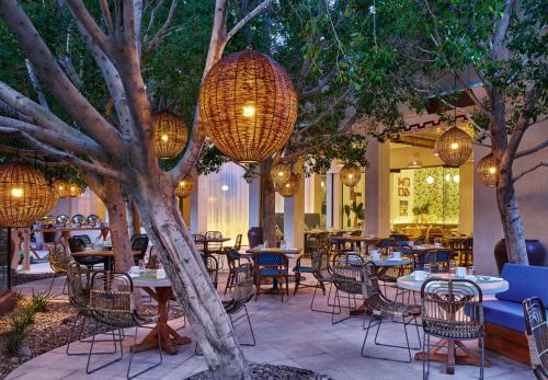a patio with tables and chairs and chandeliers at Riviera Resort Palm Springs in Palm Springs