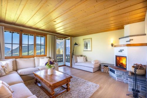 a living room with a couch and a fireplace at Villa mit Seeblick in Amden