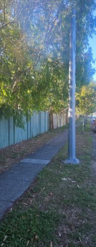 a light pole in the grass next to a fence at Aztec Adress 133 Beckett Road, mixed shared accommodation in Brisbane