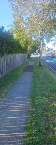 a sidewalk with a tree next to a fence at Aztec Adress 133 Beckett Road, mixed shared accommodation in Brisbane